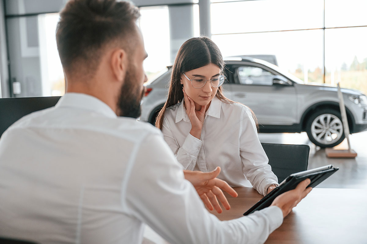 woman talking to man at car dealership